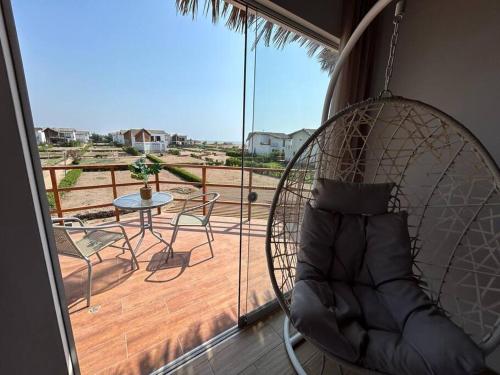 a swing in a room with a balcony with a table at Hermosa casa con vista al mar in Casa Blanca