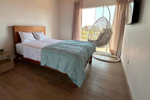 a bedroom with a bed and a chair and a window at Hermosa casa con vista al mar in Casa Blanca