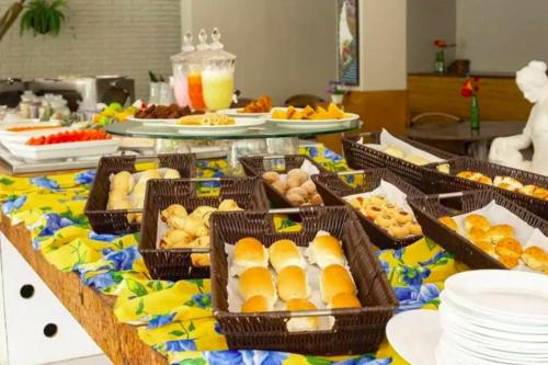 ein Buffet mit vielen Körben Essen auf dem Tisch in der Unterkunft Flat Beach Class Muro Alto - Porto de Galinhas 02 Quartos in Porto De Galinhas