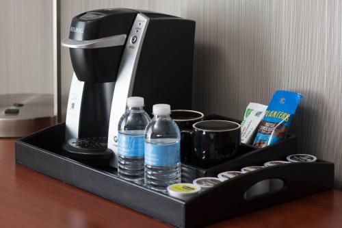 a black coffee maker with water bottles on a table at Courtyard Milpitas Silicon Valley in Milpitas