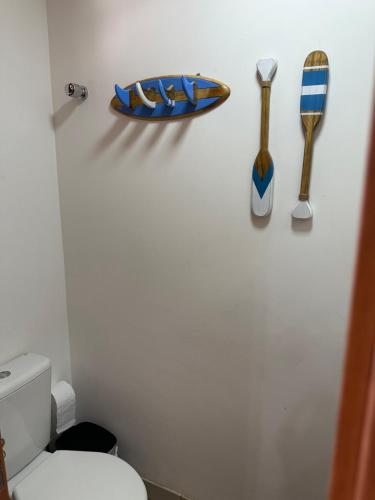 a bathroom with a toilet and utensils on a wall at OAHU in Mata de Sao Joao
