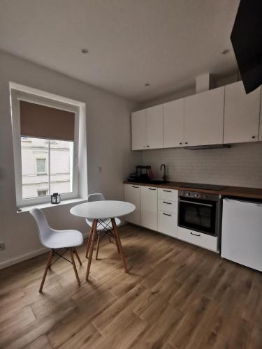 uma cozinha com mesa e cadeiras num quarto em Apartament SKALNIAK em Kudowa-Zdrój