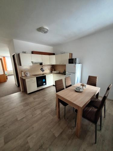 - une cuisine et une salle à manger avec une table et des chaises dans l'établissement Apartmán 254, à Janské Lázně