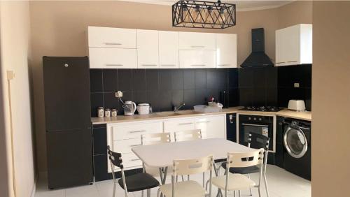 a kitchen with a white table and chairs at Modern Apartment High Standards in Monastir