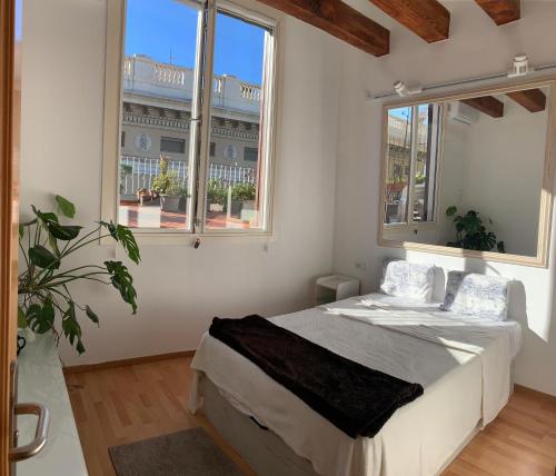 um quarto com uma cama e duas janelas em Ramblas Waterfront Stay em Barcelona