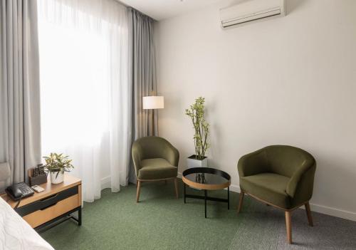 a hotel room with two chairs and a table at Evropa Hotel in Bishkek