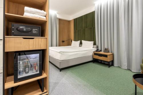 a small room with a bed and a television at Evropa Hotel in Bishkek