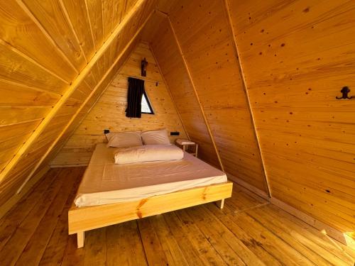 a bed in a wooden room in a wooden cabin at Byurakan Guesthouse & Cottage in Byurakan