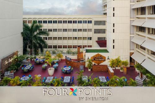 a view of a courtyard with tables and chairs in front of a building at Four Points by Sheraton Dar es Salaam New Africa in Dar es Salaam