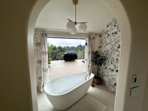 a white bath tub in a bathroom with a deck at Tranquil retreat in Los Gatos in Los Gatos