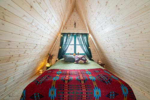 a bedroom with a bed in a small room at Cozy a-frame in the woods in Enontekiö