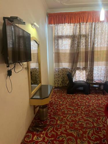 sala de estar con TV de pantalla plana y espejo en Sana Challet Manali, en Manali