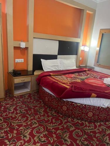 una habitación de hotel con una cama grande y una alfombra roja en Sana Challet Manali, en Manali