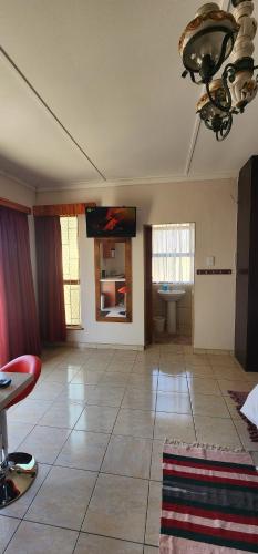 een grote woonkamer met een tafel en een wastafel bij BluePalms Guesthouse in Swakopmund