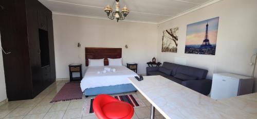a hotel room with a bed and a couch at BluePalms Guesthouse in Swakopmund