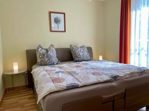 a bed with a quilt on it in a bedroom at Appartement Kastelo Teraso in Zalacs&aacute;ny