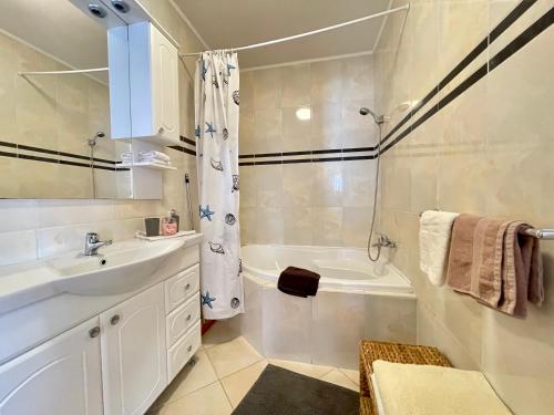 a bathroom with a sink and a tub and a shower at Appartement Kastelo Teraso in Zalacsány