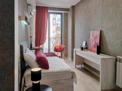 Schlafzimmer mit einem Bett, einem Schreibtisch und einem Fenster in der Unterkunft Round Garden Hotel in Tbilisi City