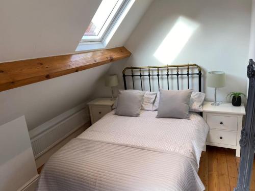 Un dormitorio con una cama con sábanas blancas y una ventana. en Sandside Retreat, en Whitby