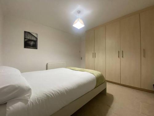 a bedroom with a large white bed and cabinets at Boss Breaks- Newcastle in Lemington