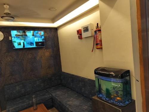 a room with a fish tank and a tv on the wall at HOTEL RJ RESIDENCY in Ahmedabad