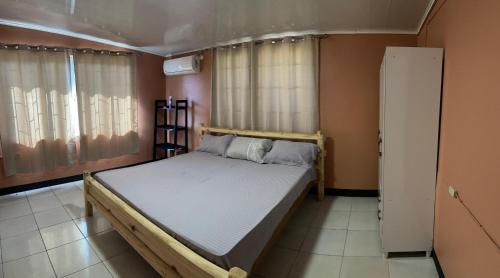 um quarto com uma cama e uma janela em Osso fu mi ati (huis van mijn hart) em Paramaribo