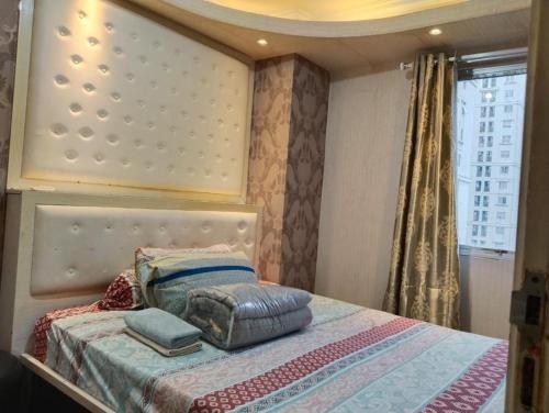 a bedroom with a bed with pillows on it at Apartemen Kalibata City By Diamond Property in Jakarta