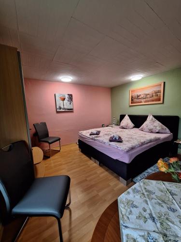 a bedroom with a bed and a chair in it at Zimmervermietung Leuba in Ostritz