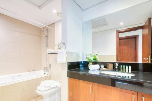 杜拜的住宿－Lovely 1 bedroom apartment for vacations，一间带水槽、卫生间和镜子的浴室