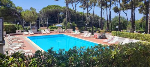 a pool with chaise lounge chairs and a resort at Studio at Castiglioncello 400 m away from the beach with sea view shared pool and enclosed garden in Castiglioncello
