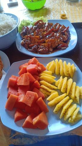 a table with two plates of food with fruits and vegetables at Tangkoko Gallery Guest House and Resto in Rinondoran