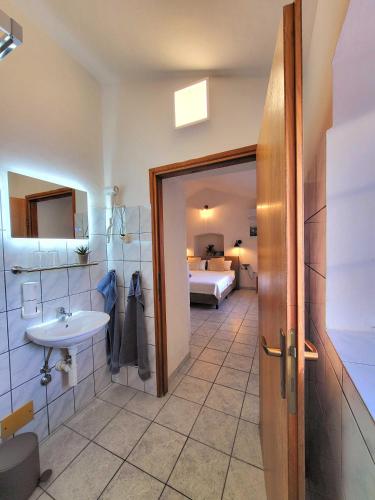 a bathroom with a sink and a bed in a room at Qća Krk Apartments in Dobrinj