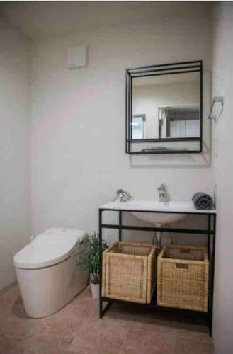a bathroom with a toilet and a mirror and a sink at Holy Planet in Tokyo