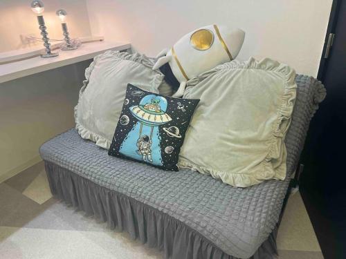 a couch with pillows on it in a room at Holy Planet in Tokyo