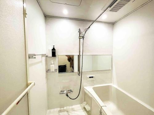 a white bathroom with a shower and a sink at Holy Planet in Tokyo