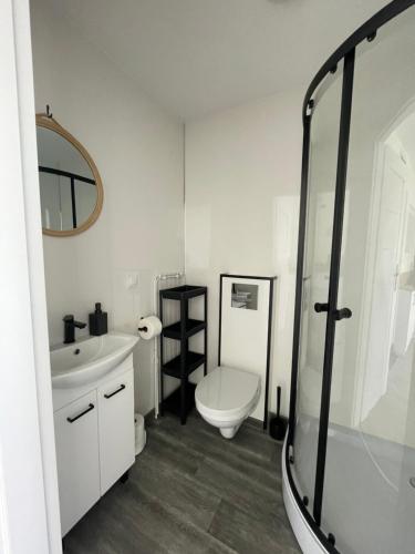 a white bathroom with a toilet and a sink at Osada Chłopy in Chłopy