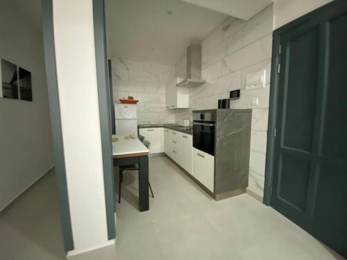 eine Küche mit einem Herd und einem Tisch darin in der Unterkunft Taflija Apartments Xemxija in St Paul's Bay