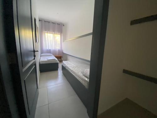 ein kleines Zimmer mit 2 Betten und einem Fenster in der Unterkunft Taflija Apartments Xemxija in St Paul's Bay