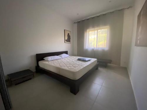 ein Schlafzimmer mit einem Bett in einem weißen Zimmer in der Unterkunft Taflija Apartments Xemxija in St Paul's Bay