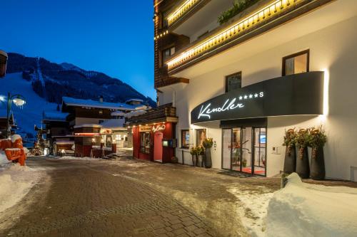 a building with a sign on the side of a street at Hotel Kendler in Saalbach Hinterglemm