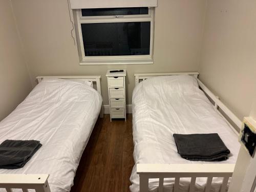 two beds in a small room with a tv at Sweet street in Barton in the Clay
