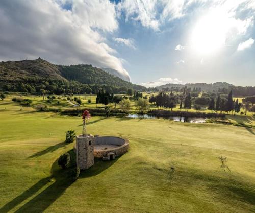 a view of a golf course with a pond at La casa de las Palmeras in Muntanya la Sella