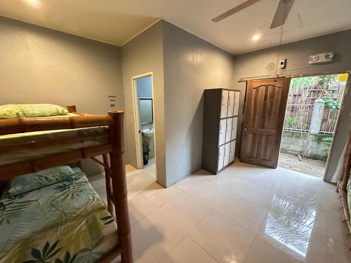 a bedroom with a bed and a door to a hallway at Lionfish Backpackers Hostel Malapascua in Daanbantayan