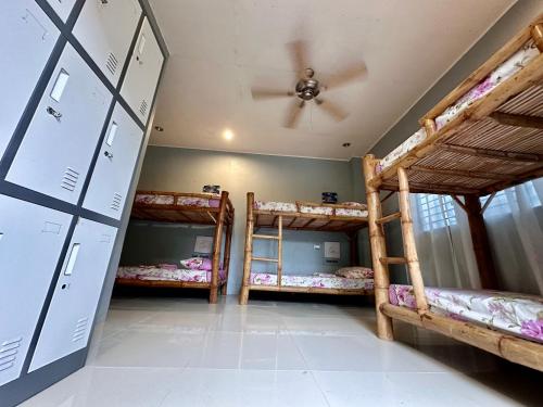 a room with three bunk beds and a ceiling at Lionfish Backpackers Hostel Malapascua in Daanbantayan