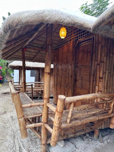 a wooden hut with a bench in front of it at Lionfish Backpackers Hostel Malapascua in Daanbantayan