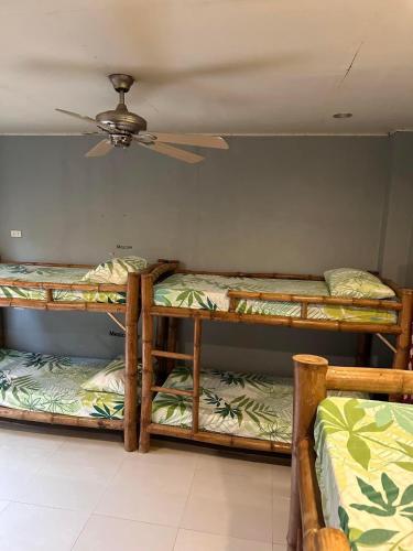 three bunk beds in a room with a ceiling at Lionfish Backpackers Hostel Malapascua in Daanbantayan