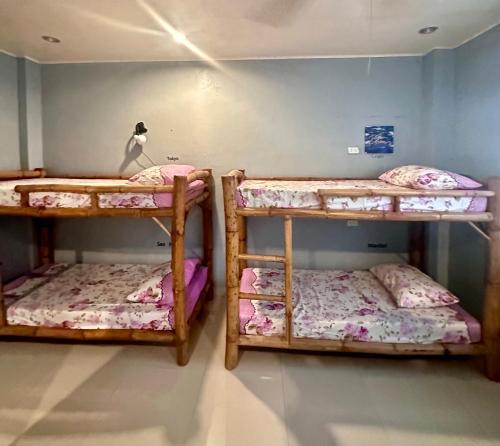 a room with three bunk beds in a room at Lionfish Backpackers Hostel Malapascua in Daanbantayan