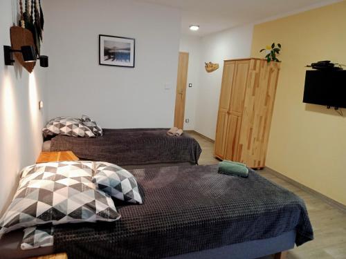 a bedroom with two beds and a wooden cabinet at Wetlina Poza Trasą in Wetlina