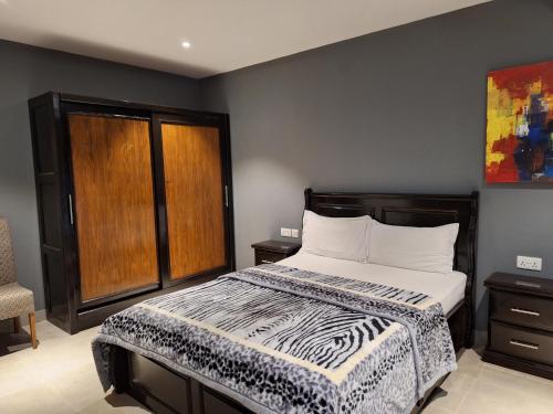 a bedroom with a bed with a zebra patterned blanket at Forest View Apartments in Kololi