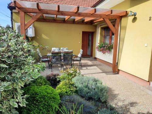 a patio with a table and chairs under a wooden pergola at Penzion Kateřina in Mikulčice
